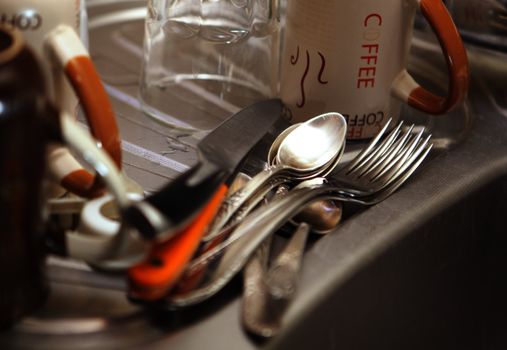 kitchen tools and washbath with soap on the bottom of a sink