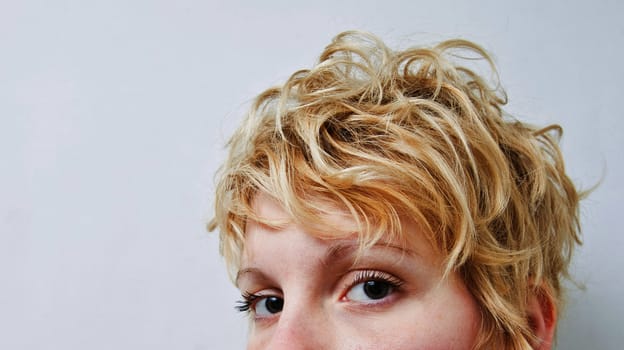 Young blond girl with morning look and mixed hairs on a white background