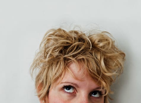 Young blond girl with morning look and mixed hairs on a white background