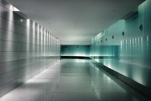 Back-lighted white glass walls in an underground metro station corridor. Contemporary interior design. This is part of the Square-Victorial tunels in Montreal