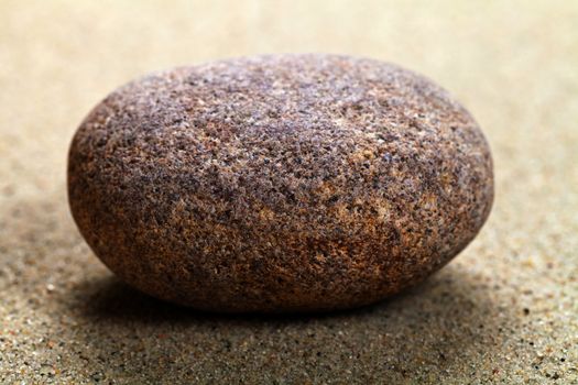 Beige stone in sand. Nature background. Macro shot
