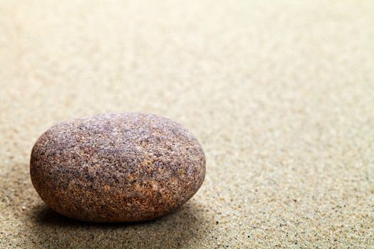Beige stone in sand. Nature background with copy space. Macro shot