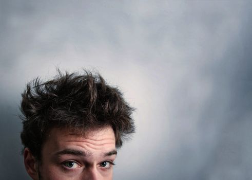 Funny morning look of a young adult men with on a white (greenish/blueish) background - not "isolated". This is also the Hangover or just "a bad night" look. You can see a bit of fatigue.