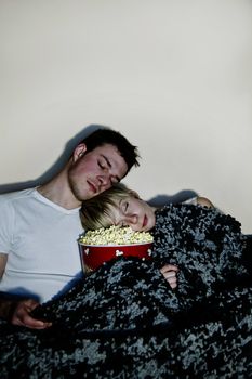 Eating a huge bowl of fresh buttered popcorn comfortably wrapped in a blanket. The movie might be a bit boring since both of then are sleeping... in the popcorn !!!