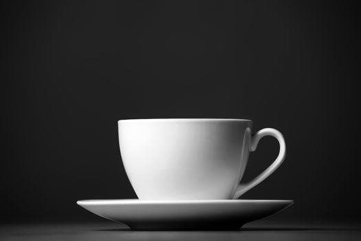 White mug and saucer on a gray background.