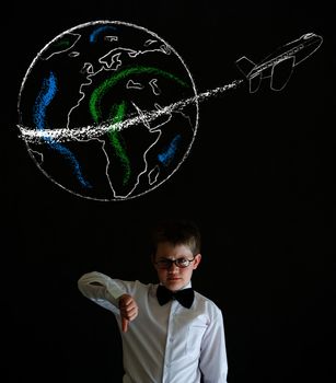 Thumbs down boy dressed up as business man with chalk globe and jet world travel on blackboard background