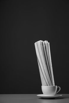 White mug and newspaper on a gray background