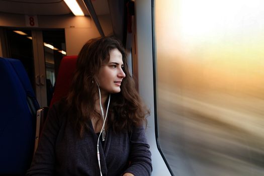 woman looks out the window while sitting in the train.