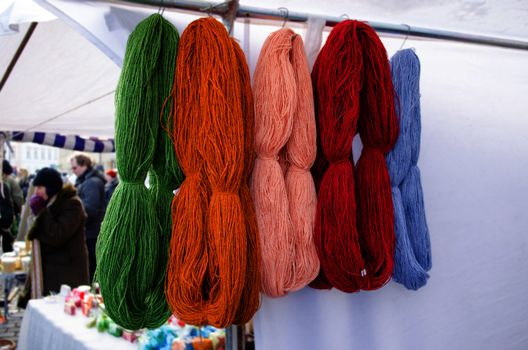 woollen wool colorful natural thread bunches hang sell in outdoor street market fair.