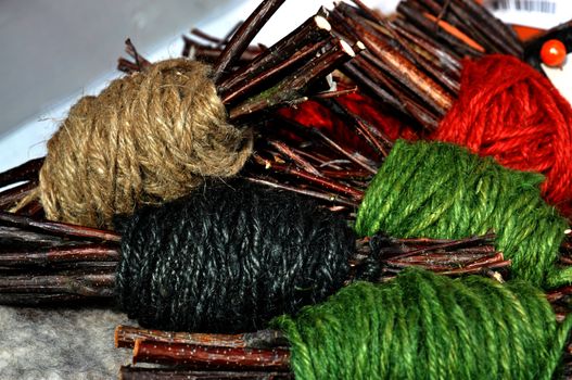 Handmade yarn skeins in a bundle with twigs as a part of interior decoration.