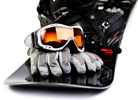 Snowboard with boot helmet gloves and goggles on white background