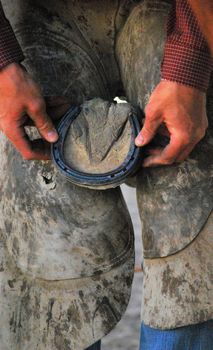 Farrier working on horse shoes on a ranch.