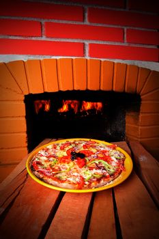 Pizza baking with wood fire in the oven 