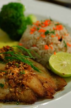close up grilled fish served with fried rice