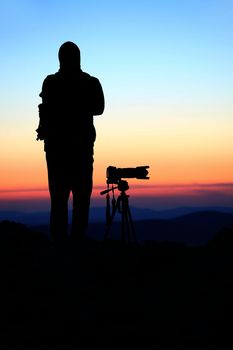 Silhouette of a landscape photographer in twilight