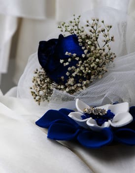 a  blue roses and wedding rings on white background