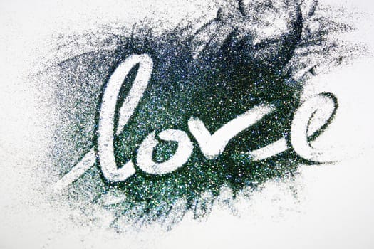 The word love written on colored glitter powder