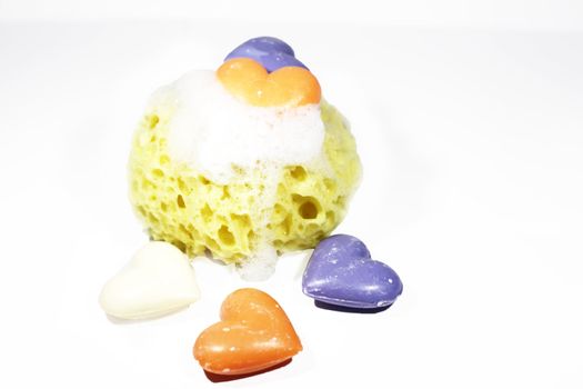 A yellow sponge in soap bubbles with some colored soap