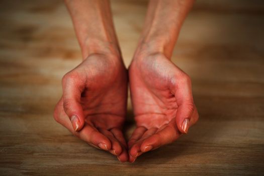 Opened female hand on a wooden background