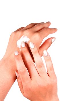 Female applying hand cream on white