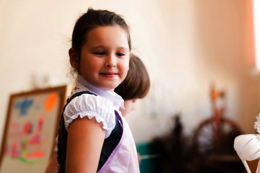 Portrait of Asian girl in apron interested in painting at an art school