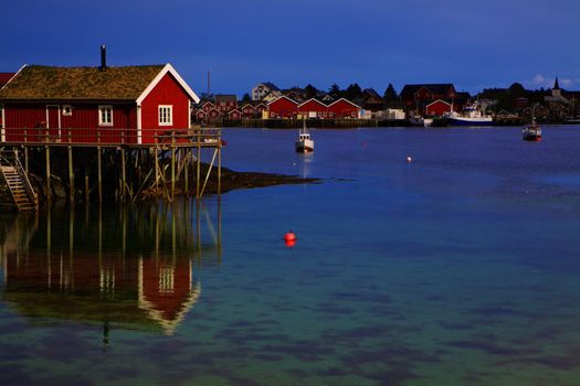 Typical red rorbu hut in fishing harbour in scenic town Reine on Lofoten islands in Norway