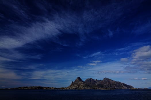 Rocky island in norwegian sea near Bodo on sunny summer day