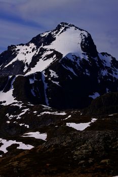 Scenic rocky mountain covered by snow on Lofoten islands in Norway