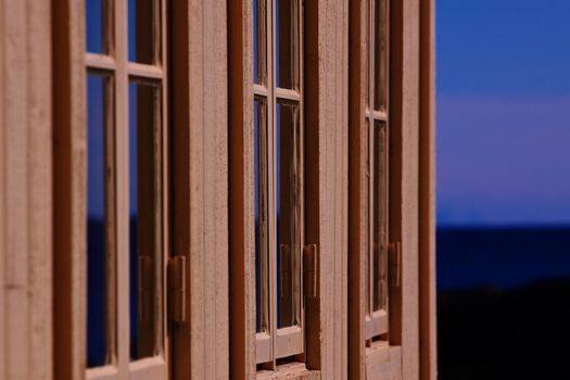 Row of three wooden windows on building facade