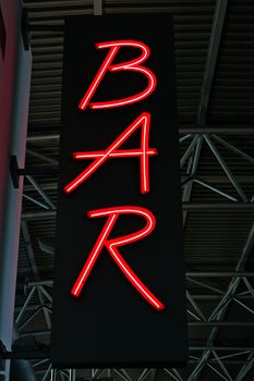 Red neon light as advertisement for a Bar