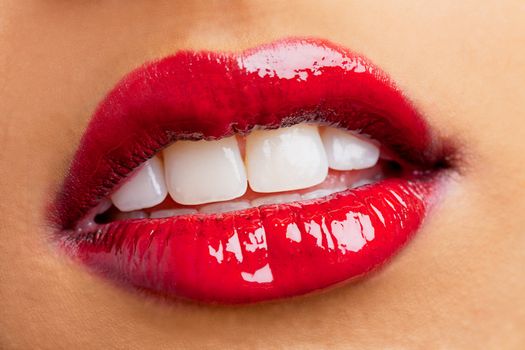Close-up shot of woman lips wearing red shiny lipstick, Kiran Bahugun