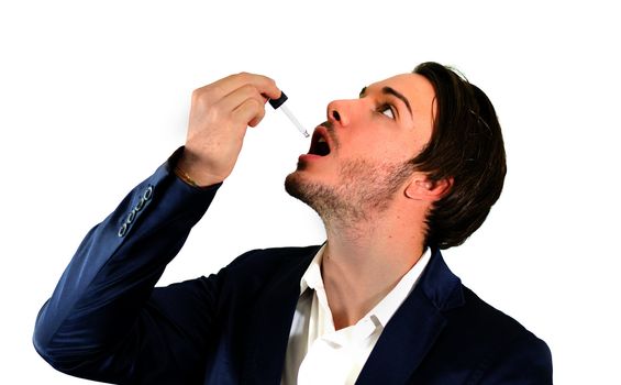 Young man using dropper pipette on his mouth for medicine, drug treatment