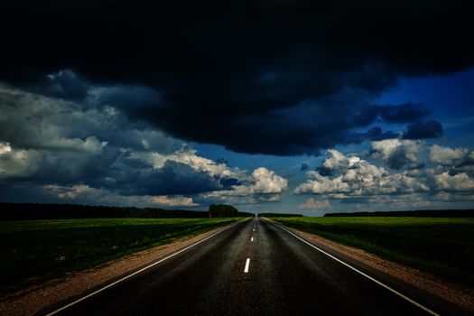 Travel concept background - road and stormy sky