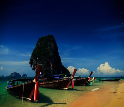 Holiday vacation concept background - Long tail boat on tropical beach with limestone rock, Krabi, Thailand