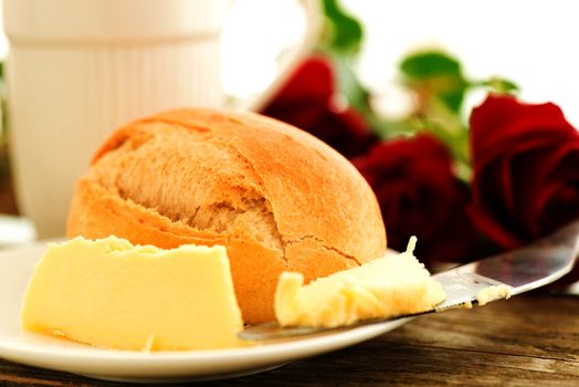 Bread butter and roses on wooden table - romantic breakfast  composition