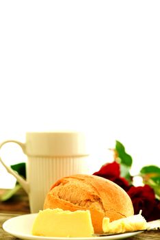 Bread butter and roses on wooden table - romantic breakfast  composition with copy space