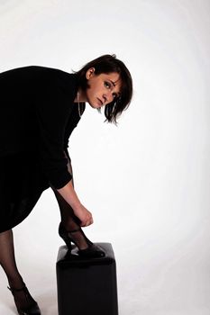 a young woman in strict black dress in studio looking like widow or nanny