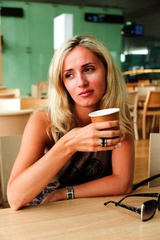 Sad eastern european blond woman drinking coffee