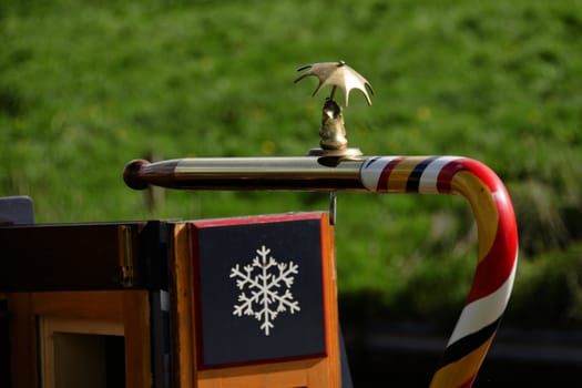 Narrowboat tiller with brass animal figure holding an umbrella