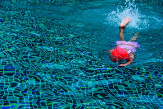 kid swimming on a blue water pool