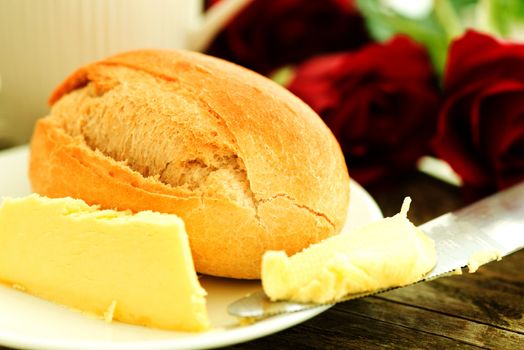 Bread butter and roses on wooden table - romantic breakfast  composition