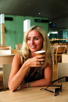 Eastern european blond woman drinking coffee and smiling