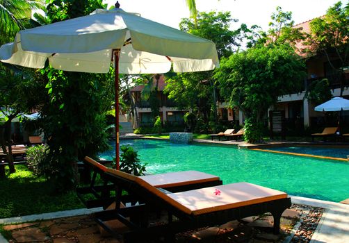 Beach chairs and umbrella side swimming pool