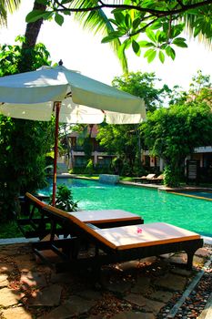 Beach chairs and umbrella side swimming pool