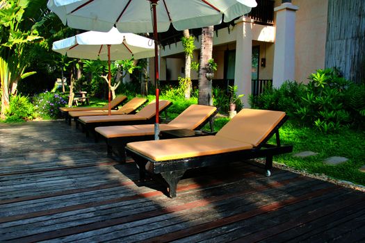 Beach chairs and umbrella side swimming pool