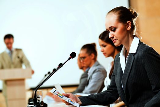 businessmen communicate at the conference, sitting at the table, on the table microphones and documents