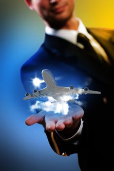 pilot in the form of extending a hand to a flying airplane with sky, clouds and sun