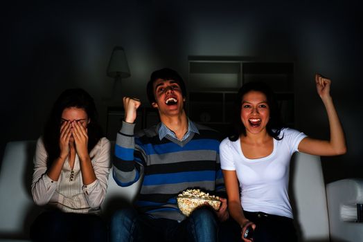 group of young people watching TV on the couch, sports fans