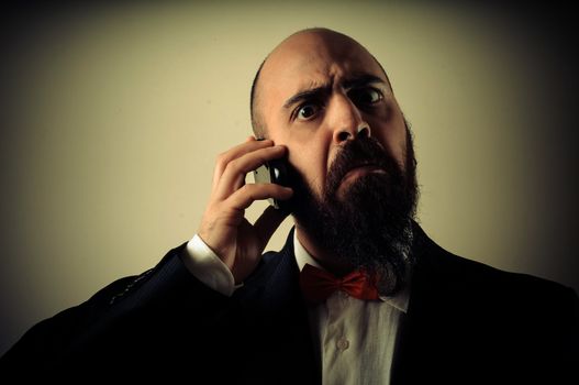  funny elegant bearded man on the phone on vignetting background