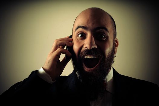  funny happy elegant bearded man on the phone on vignetting background